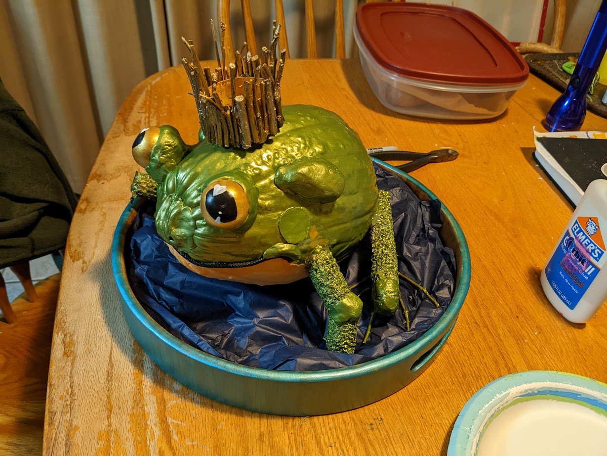 a pumpkin painted to look like a chubby frog prince